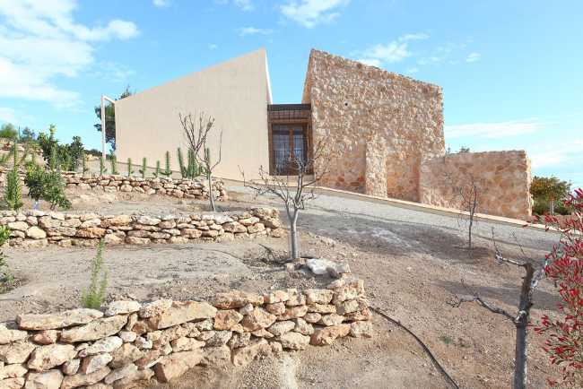 Mediterranean house situated between ploughed fields and stones. Ecological habitat in Spain