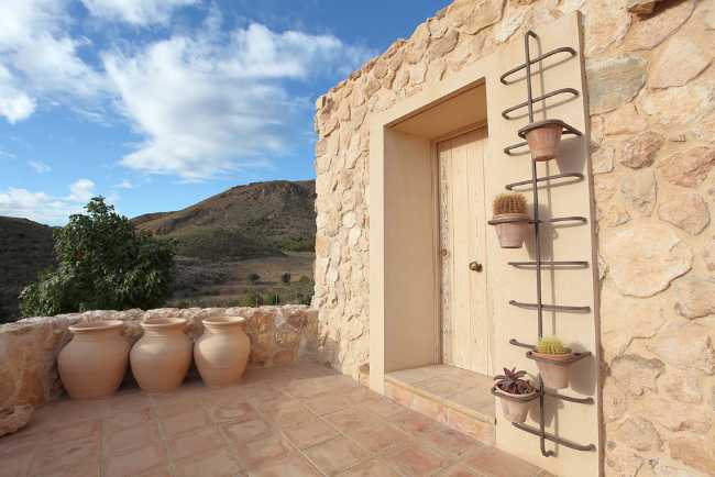 Mediterranean house situated between ploughed fields and stones. Ecological habitat in Spain