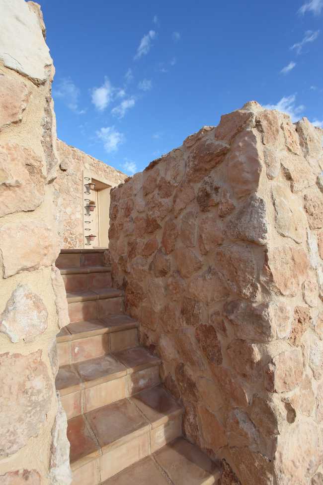 Mediterranean house situated between ploughed fields and stones. Ecological habitat in Spain