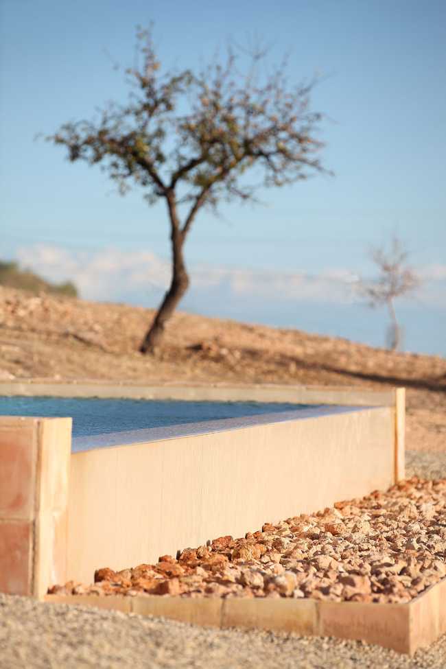 Mediterranean house situated between ploughed fields and stones. Ecological habitat in Spain