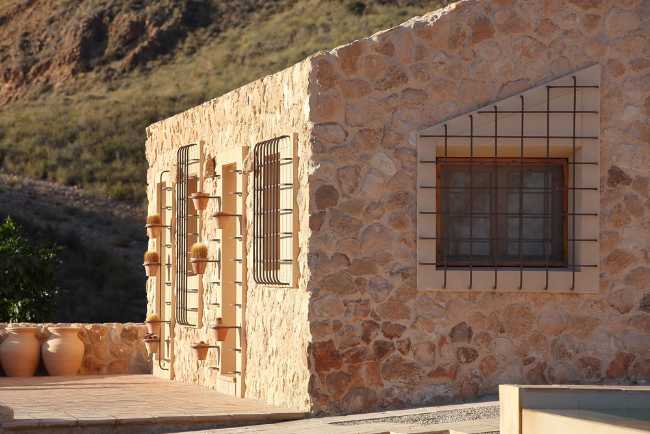 Mediterranean house situated between ploughed fields and stones. Ecological habitat in Spain