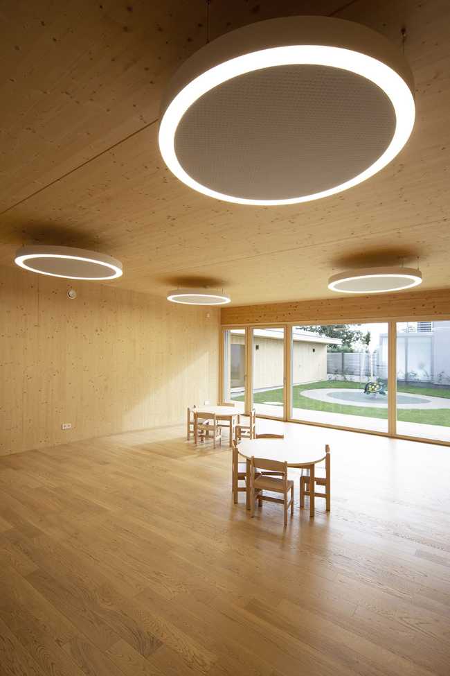 Stanza asilo nido in legno con lampade circolari