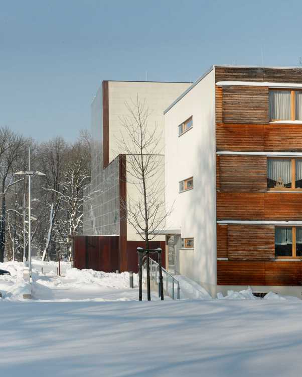 One cube, four facades. Warm, soft wood complements the white plaster façade